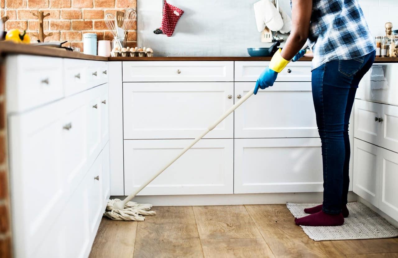 a woman cleaning the kitchen's floor